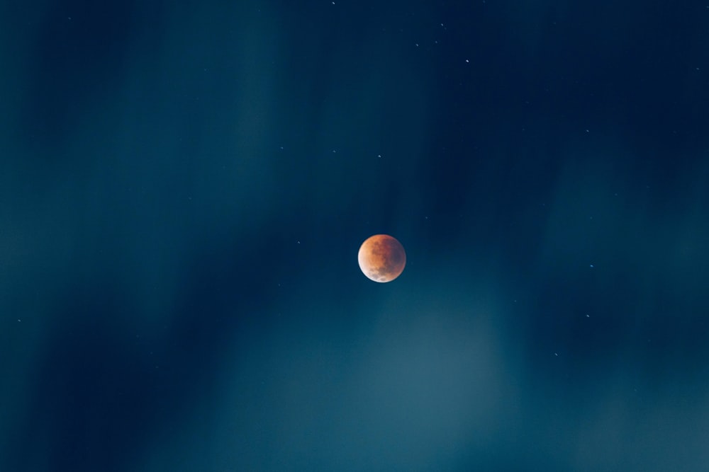 a red moon is seen in the night sky