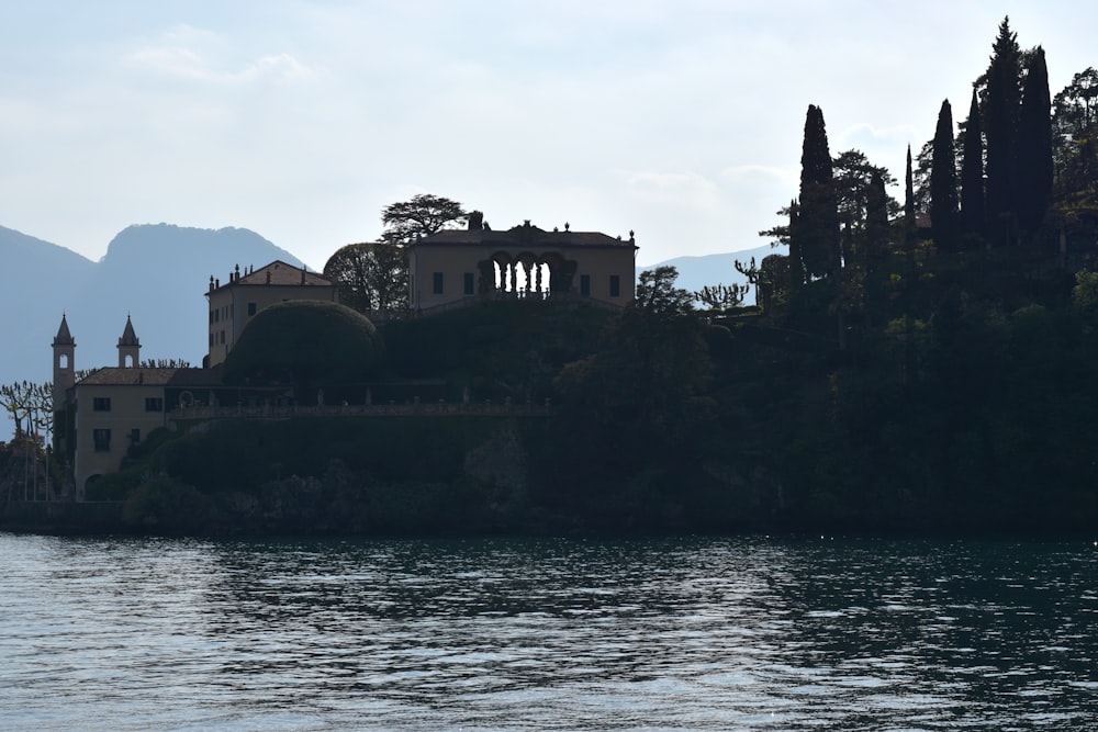 a large building sitting on top of a hill next to a body of water