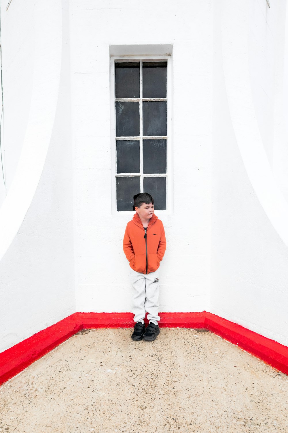 a young boy standing in front of a window