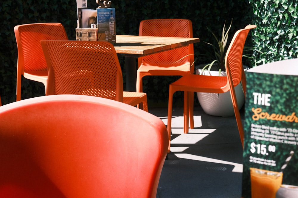 a table with orange chairs and a bottle of orange juice