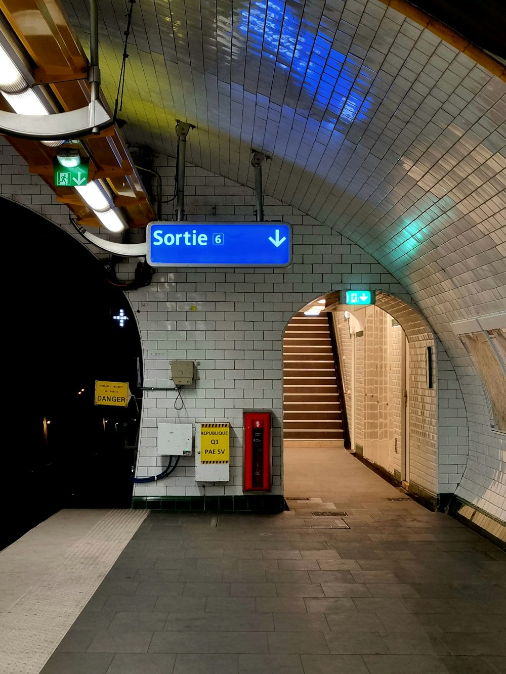 a subway station with a blue sign and stairs