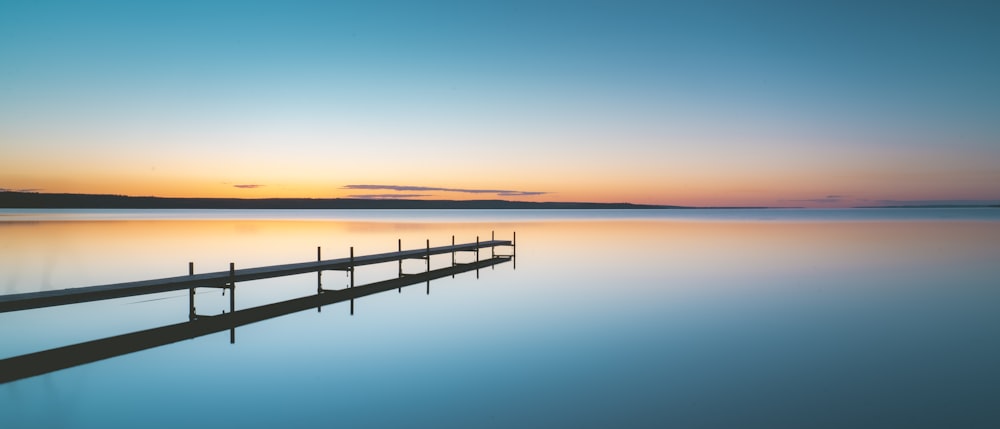 a long dock sitting in the middle of a lake