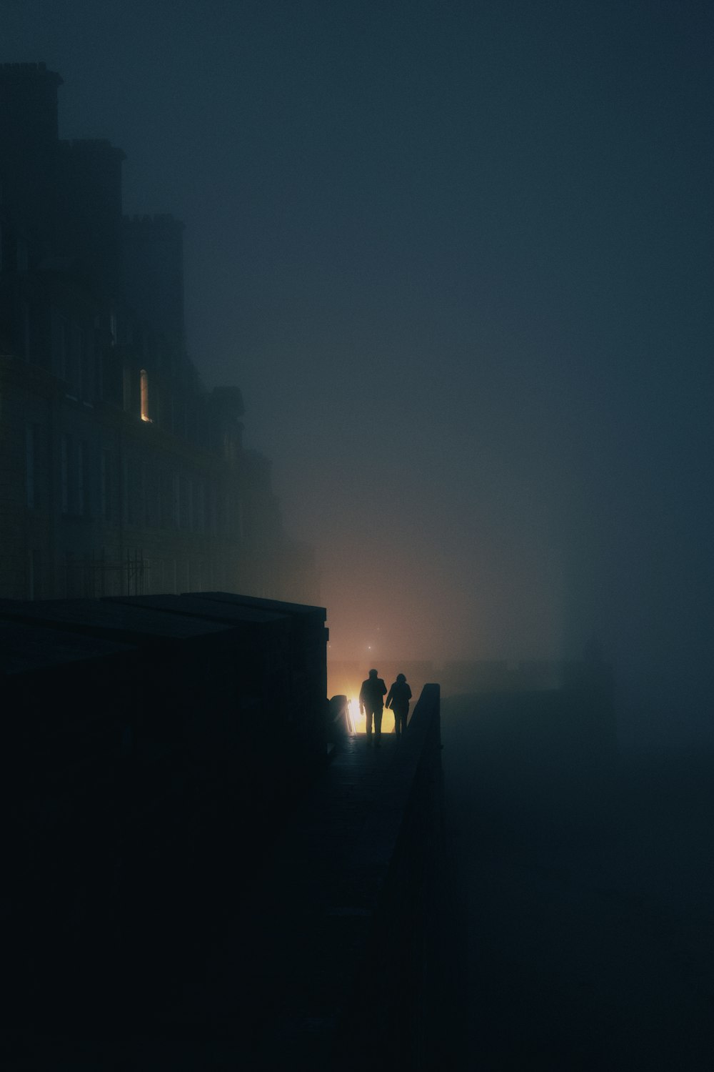 Un par de personas caminando por una calle con niebla