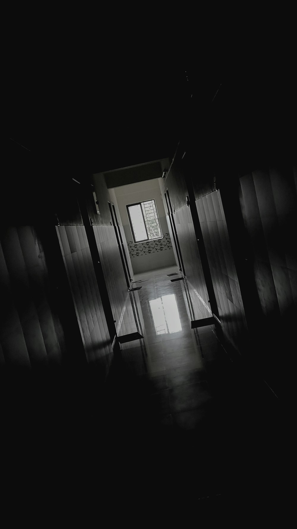 a dark hallway with a light coming through the door