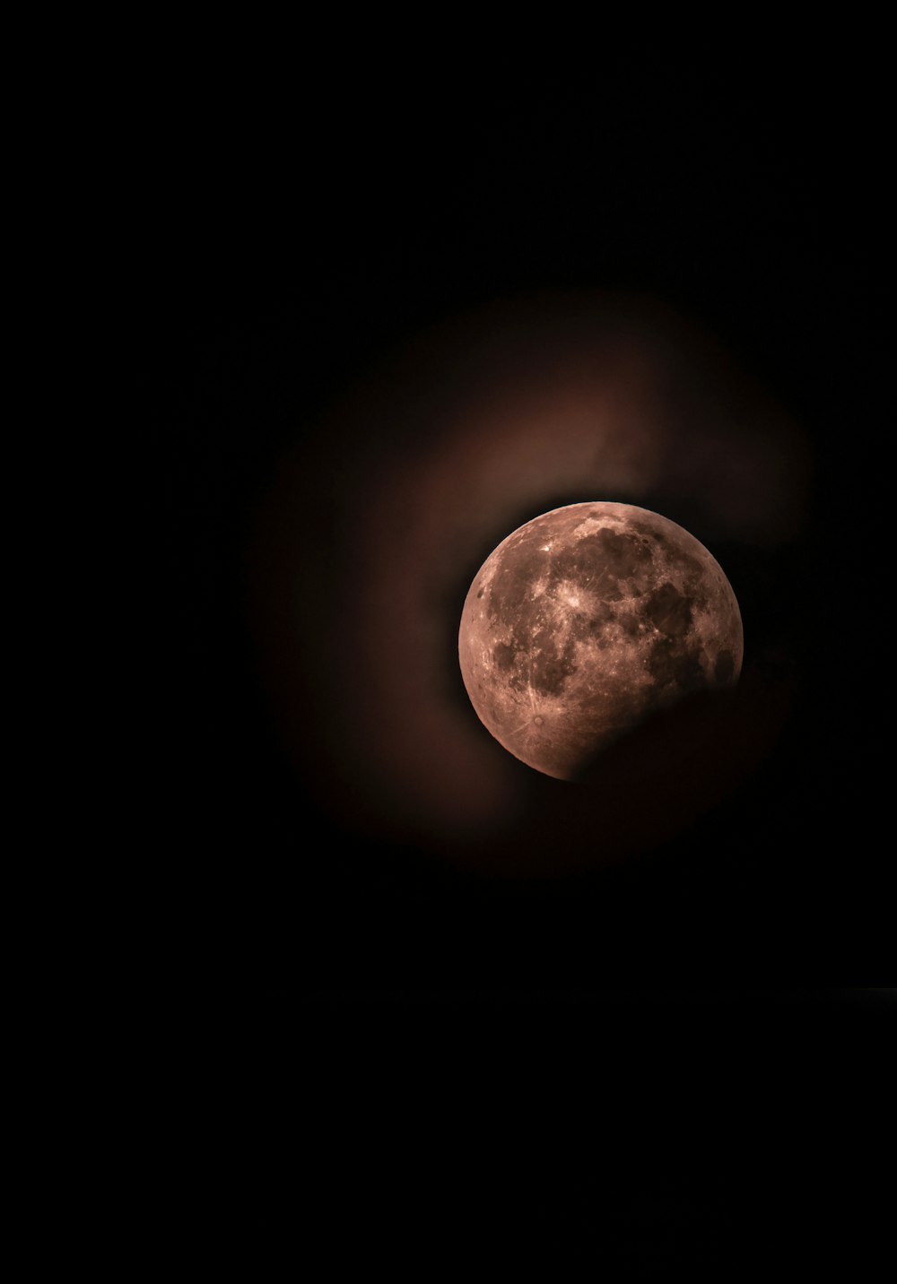 Une pleine lune vue à travers un ciel sombre