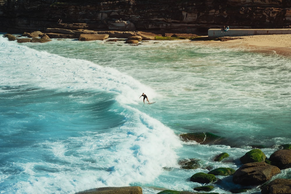 a person riding a wave on top of a body of water