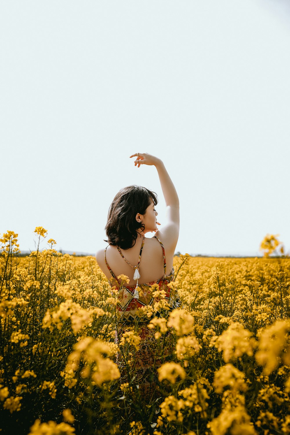 a woman standing in a field of yellow flowers