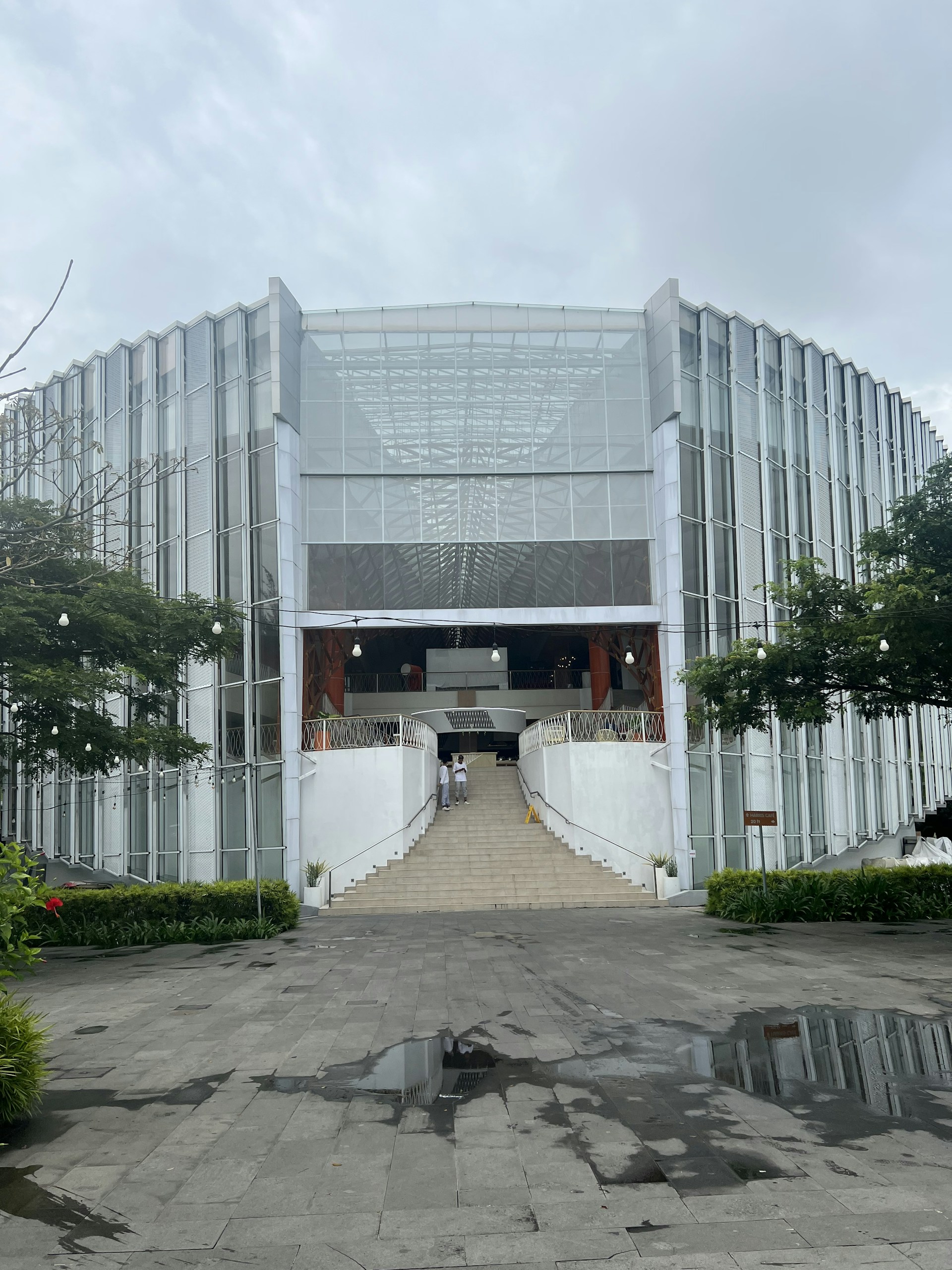 a large glass building with stairs leading to it