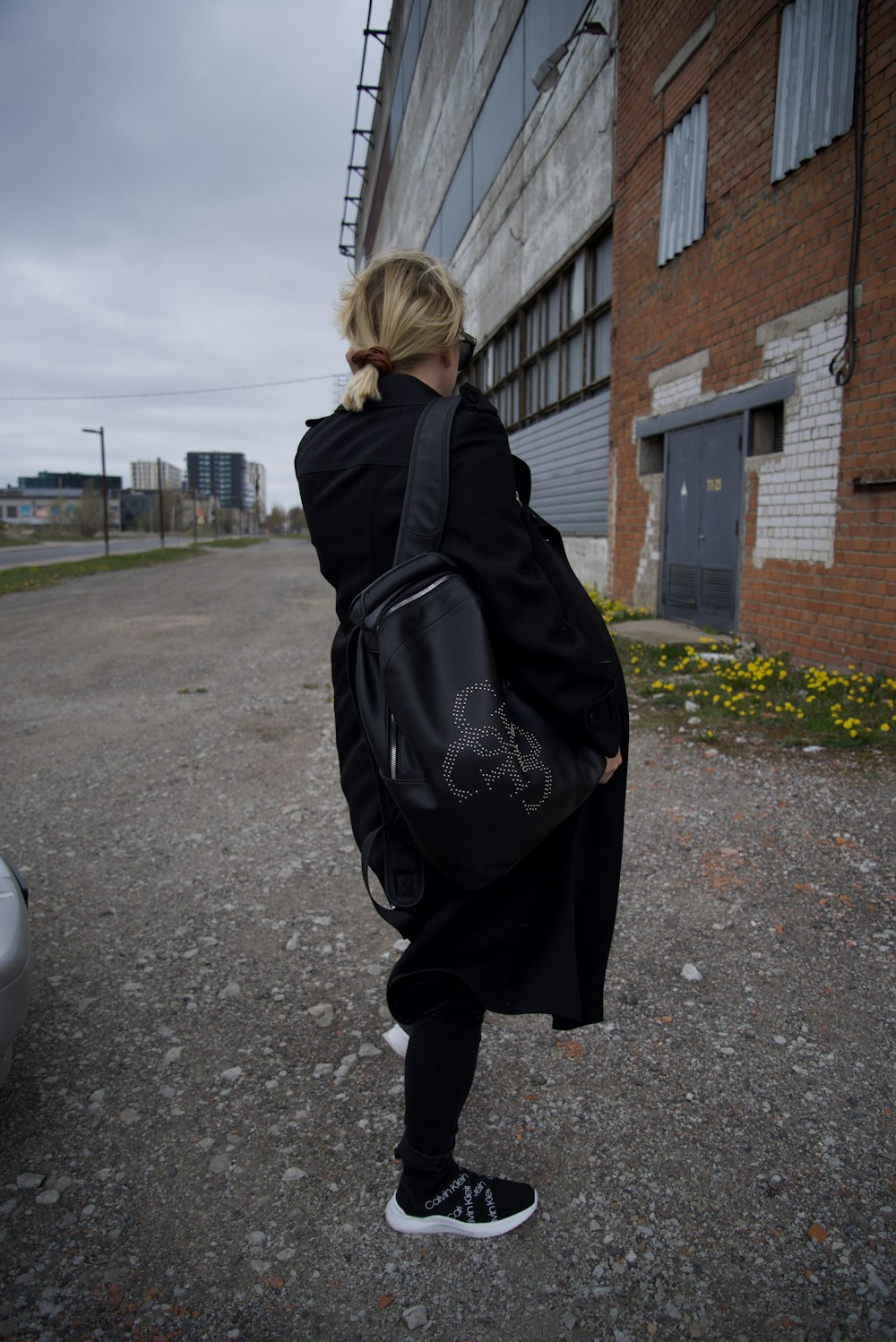 a woman in a black coat carrying a black bag