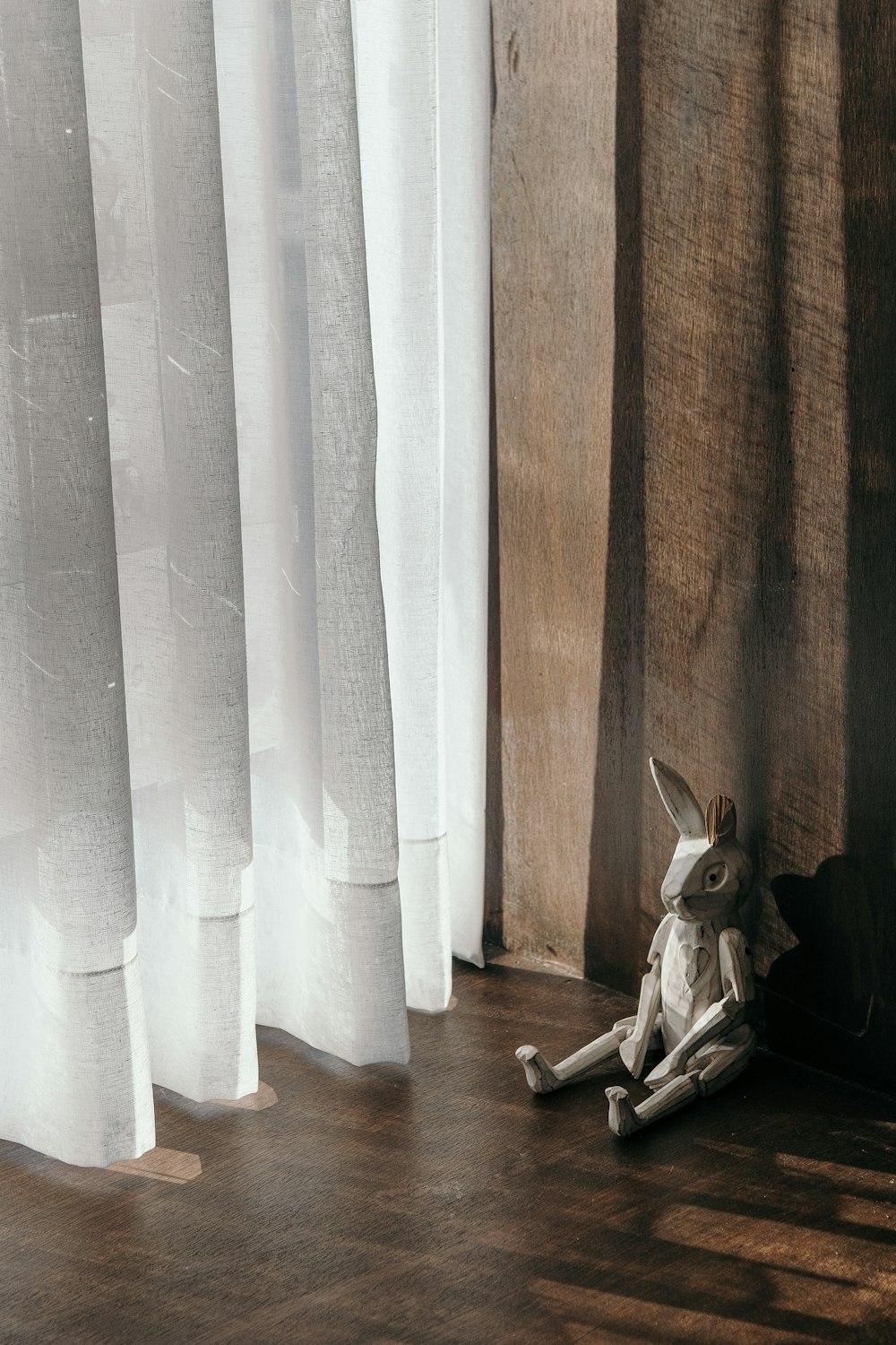 a stuffed animal sitting on the floor next to a window