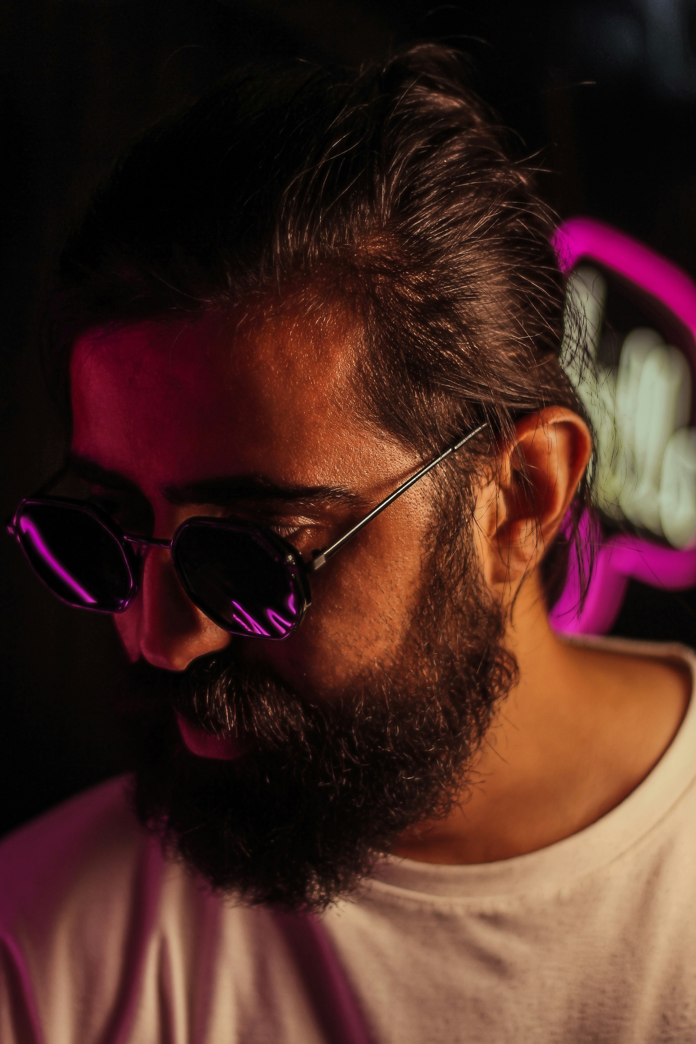 a man with a beard and sunglasses looking at his cell phone