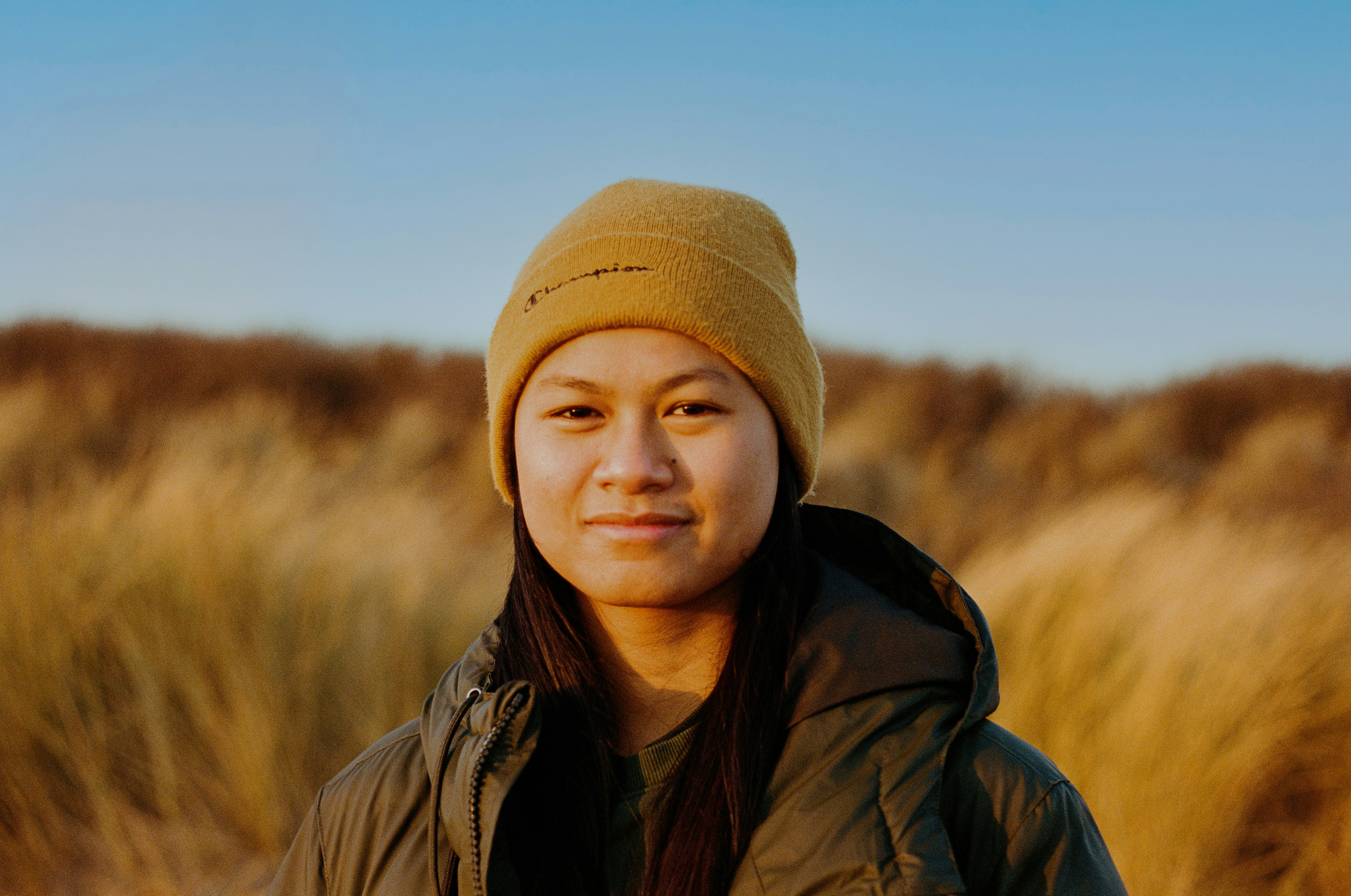 a woman standing in a field of tall grass