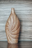 a wooden vase sitting on top of a wooden table