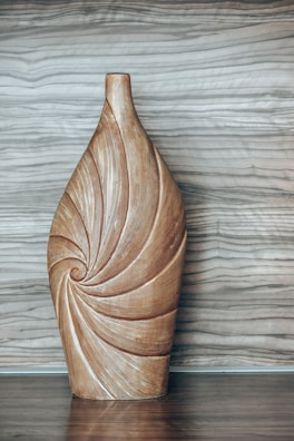 a wooden vase sitting on top of a wooden table