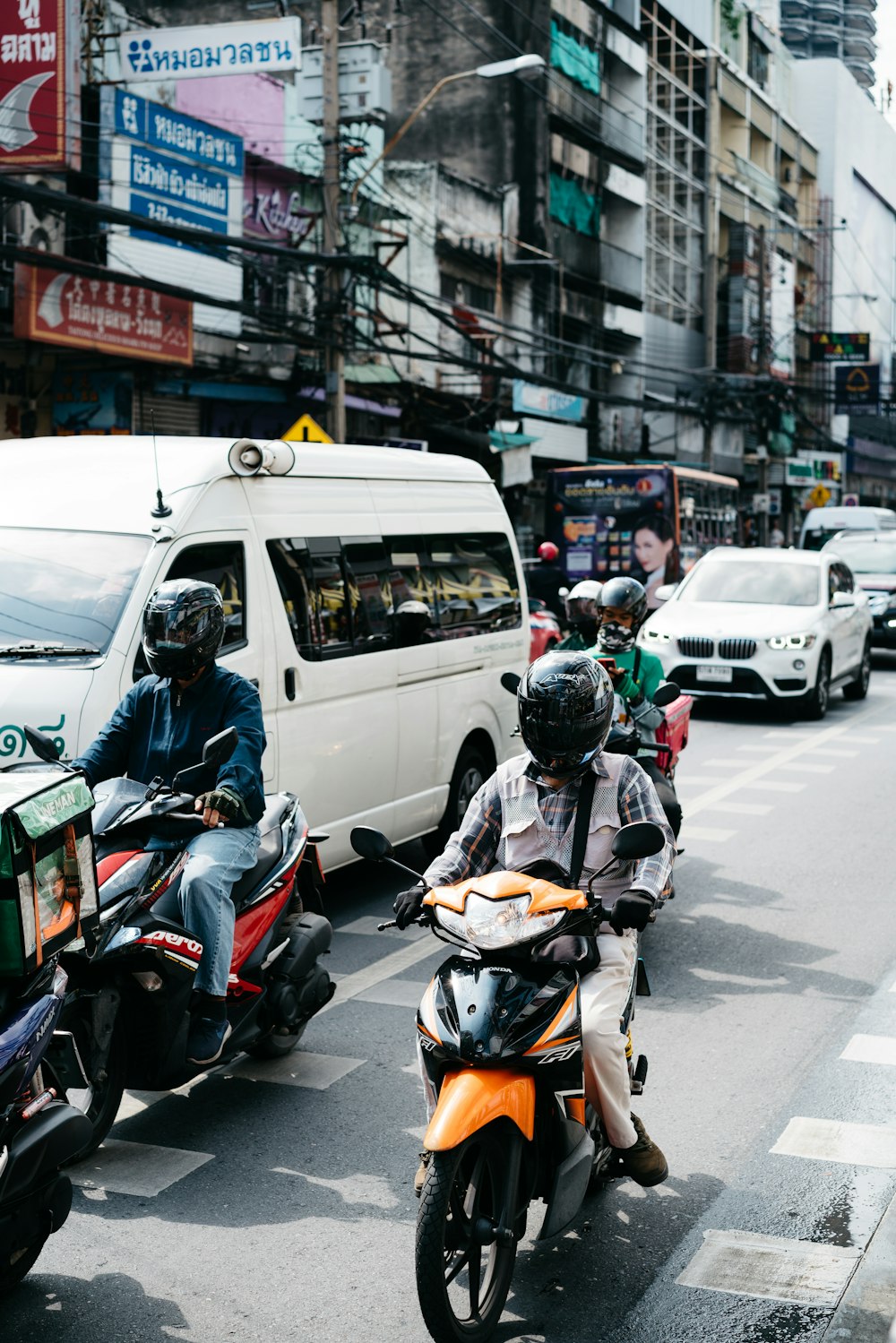 a group of people riding scooters down a street