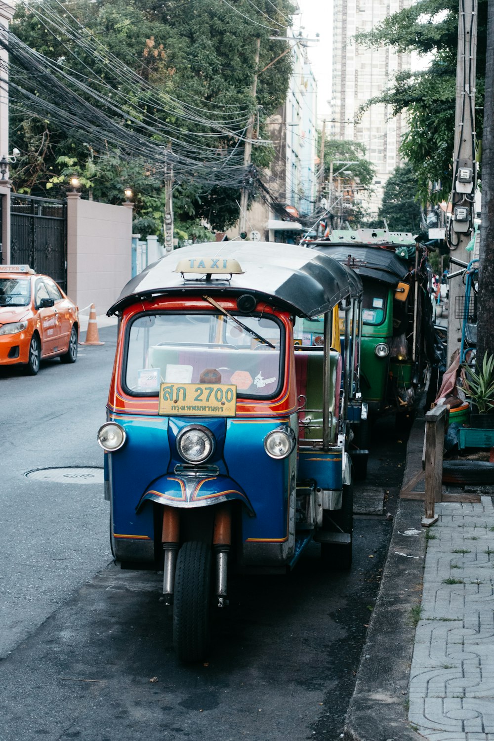 a small blue and red car parked on the side of a road