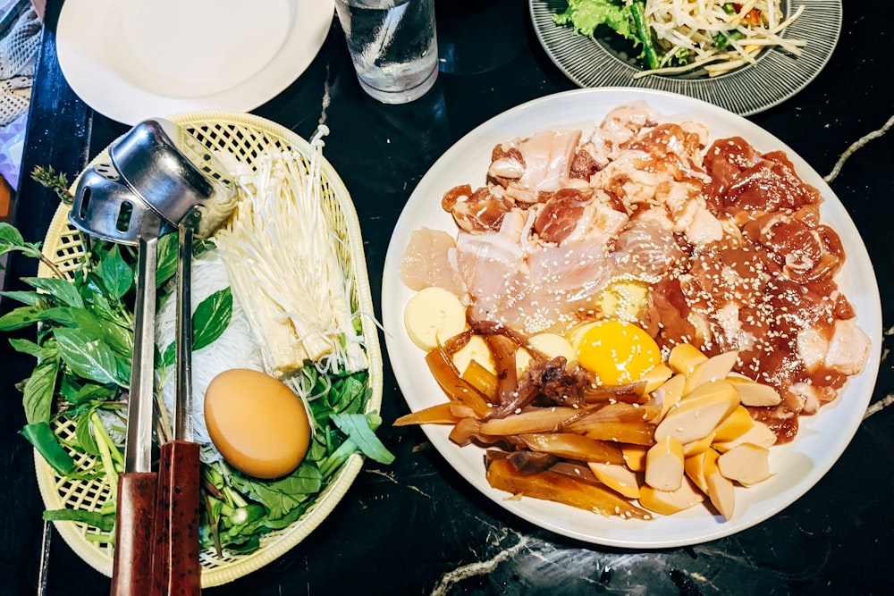 two plates of food on a table with utensils