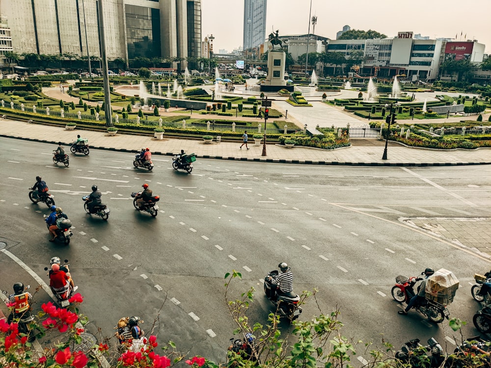 a group of people riding motorcycles down a street