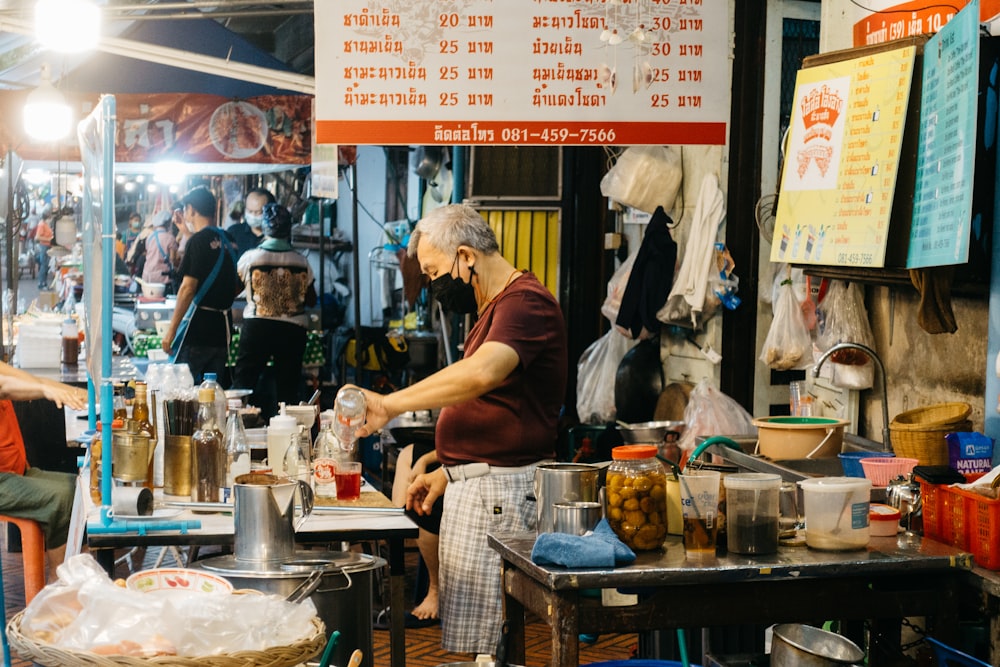 a man standing in front of a counter filled with food