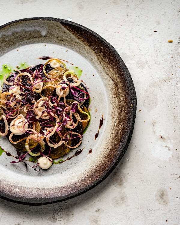 A white plate topped with a salad covered in onions