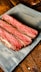 a piece of steak sitting on top of a wooden table