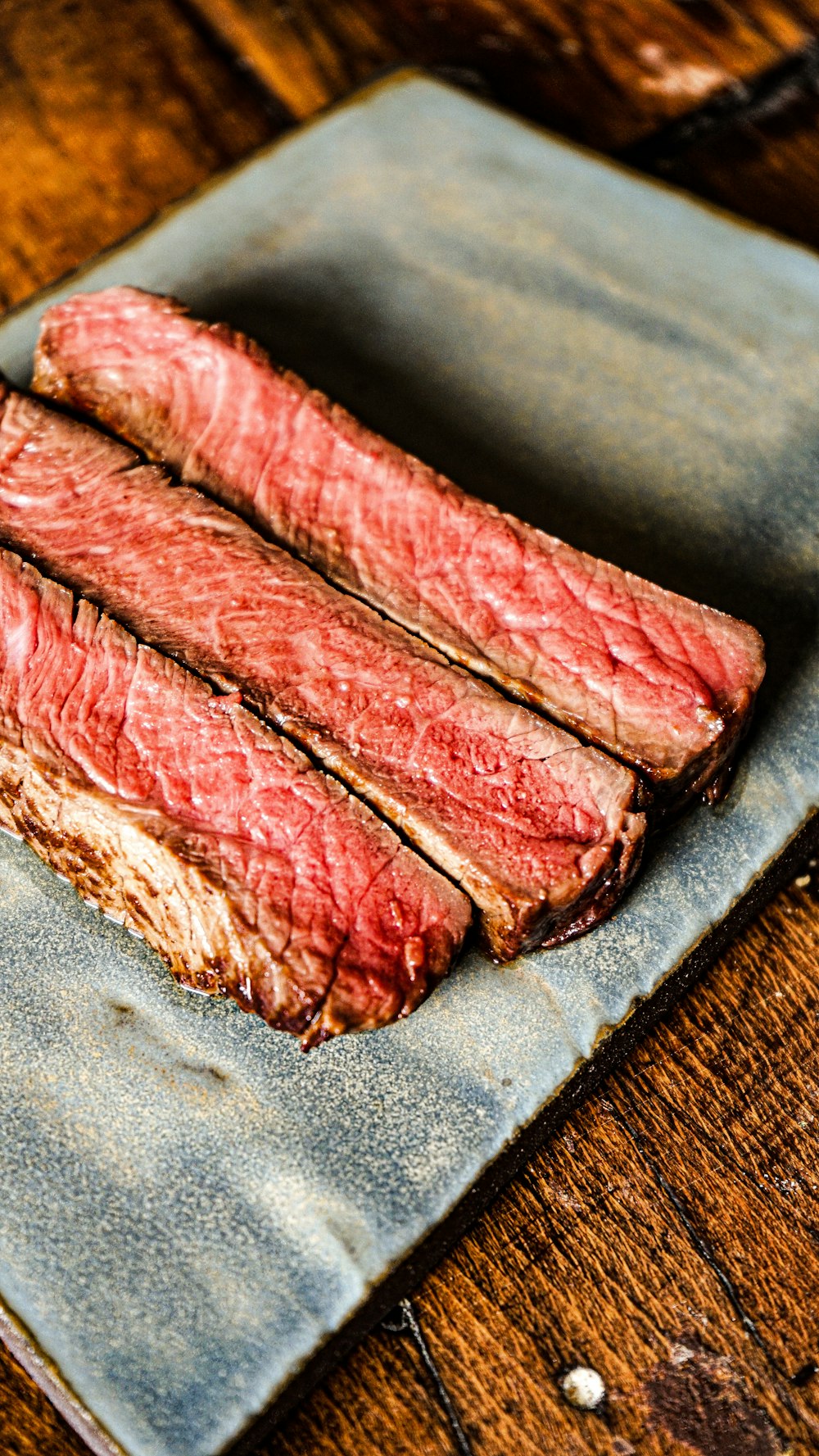 a piece of steak sitting on top of a wooden table