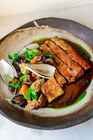 A beautifully plated main course showcasing tender grilled meat with seasonal vegetables.