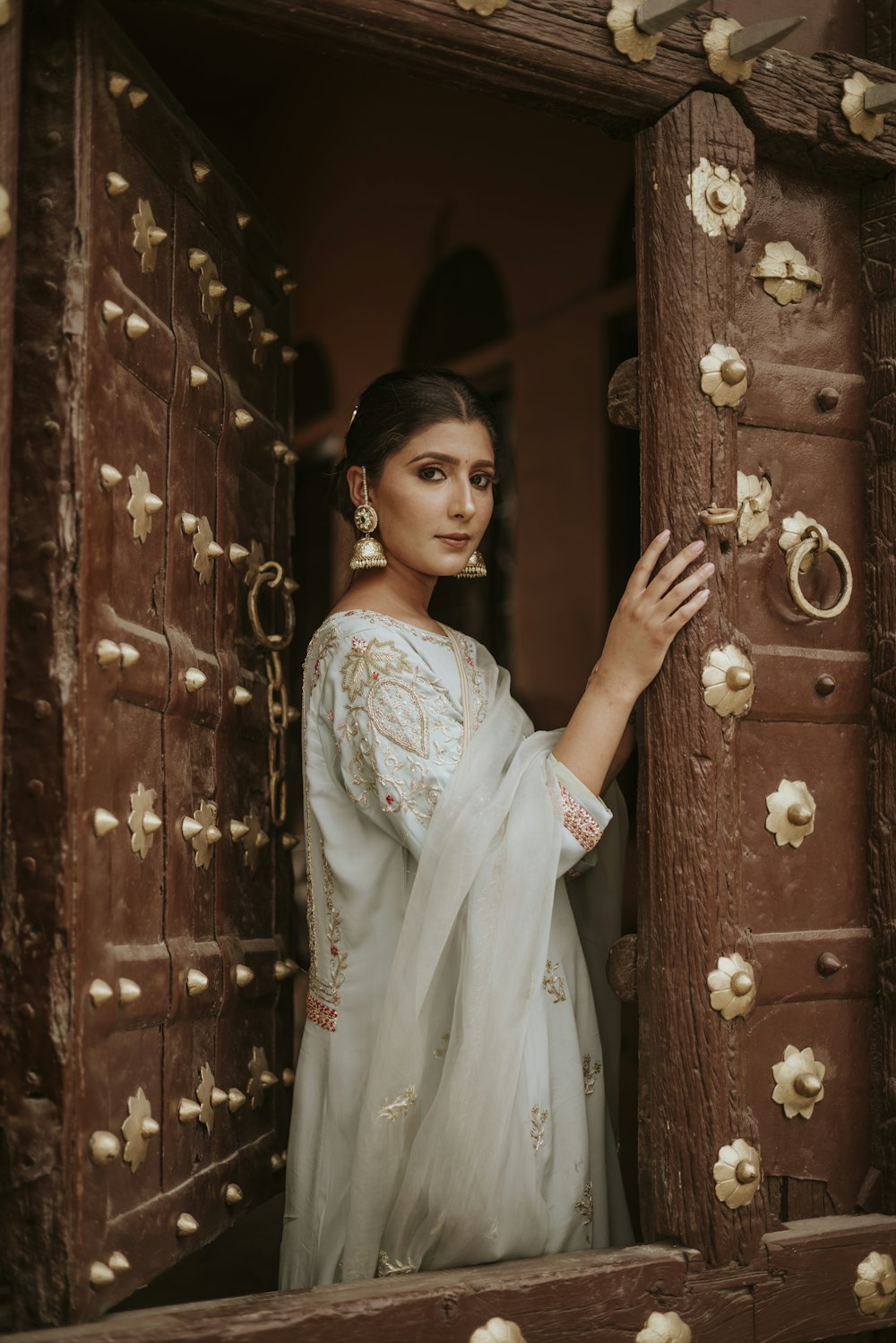 a woman in a white dress standing in a doorway