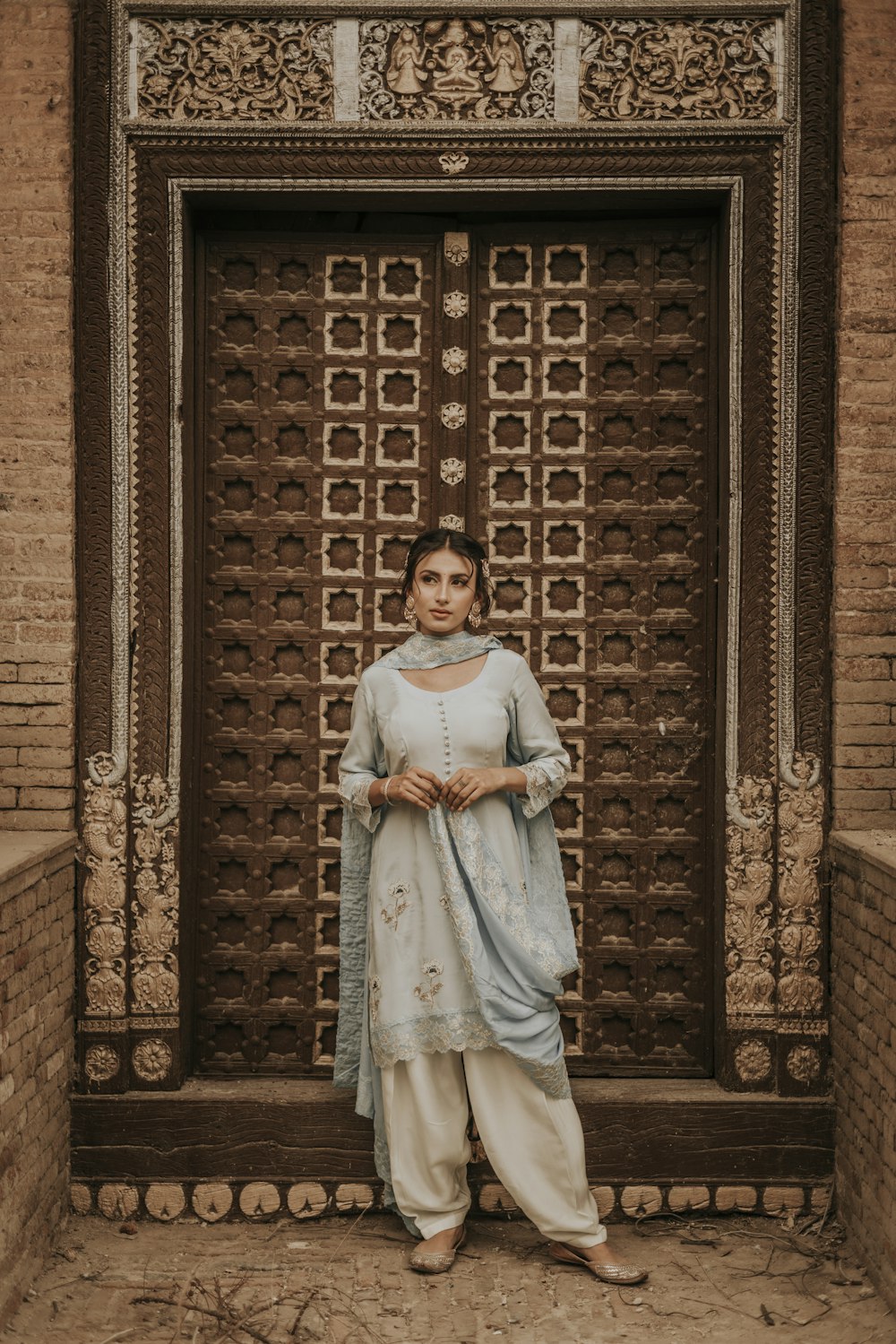 a woman standing in front of a wooden door