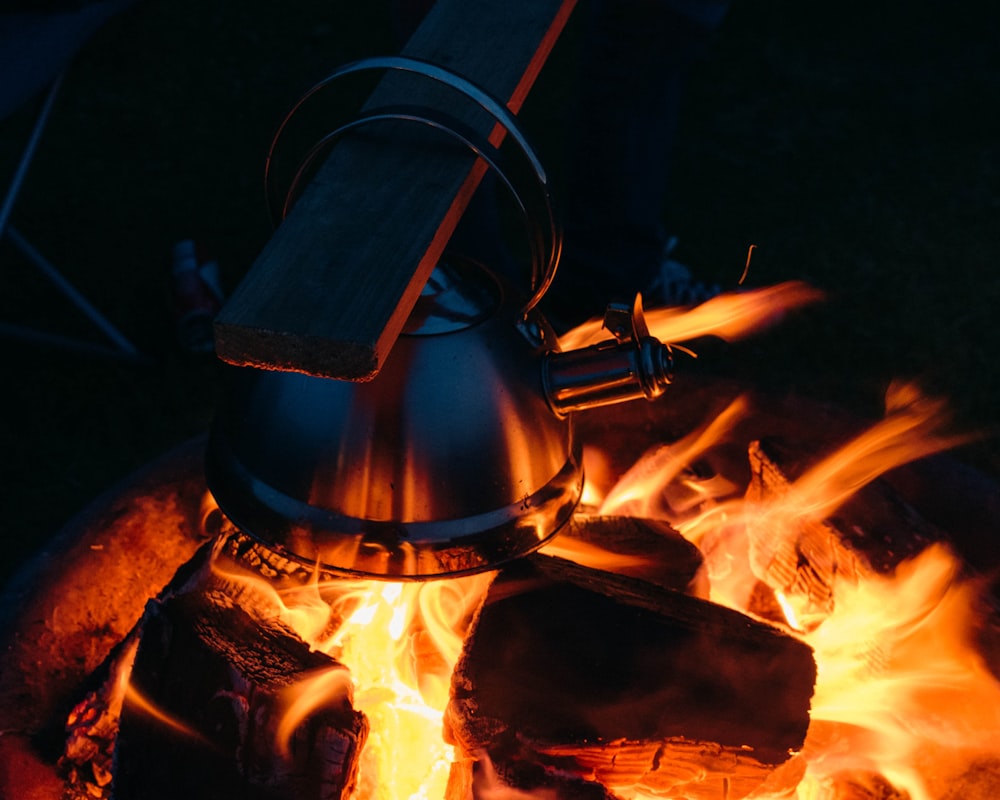 ein Wasserkocher, der auf einer Feuerstelle sitzt