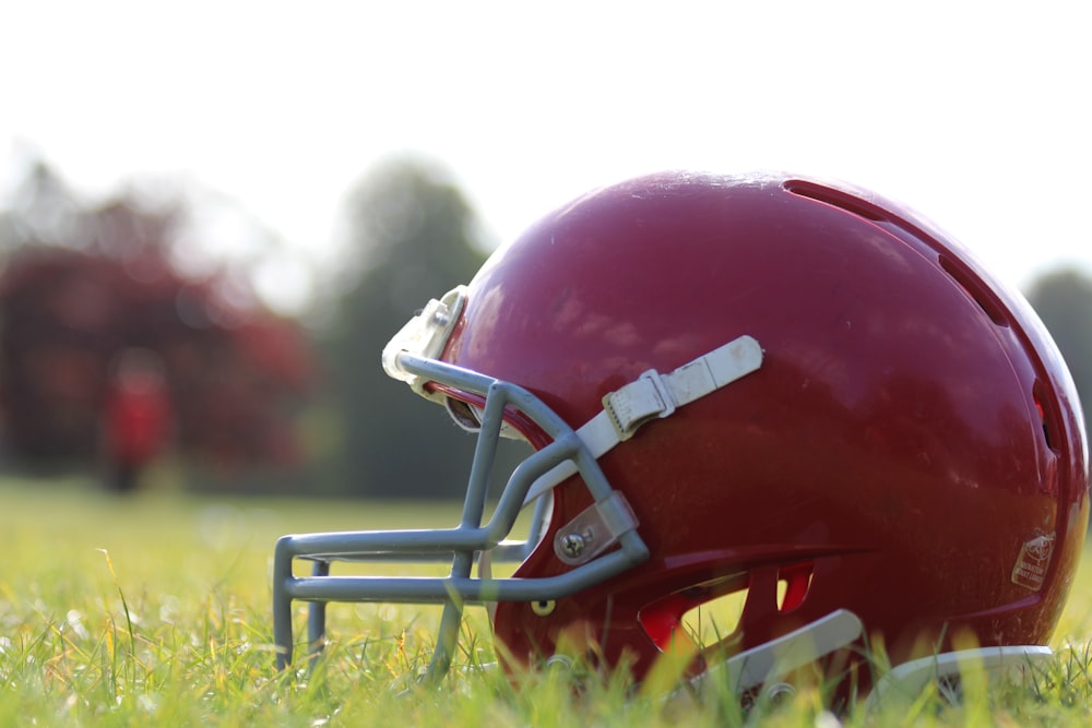 a football helmet sitting on top of a lush green field