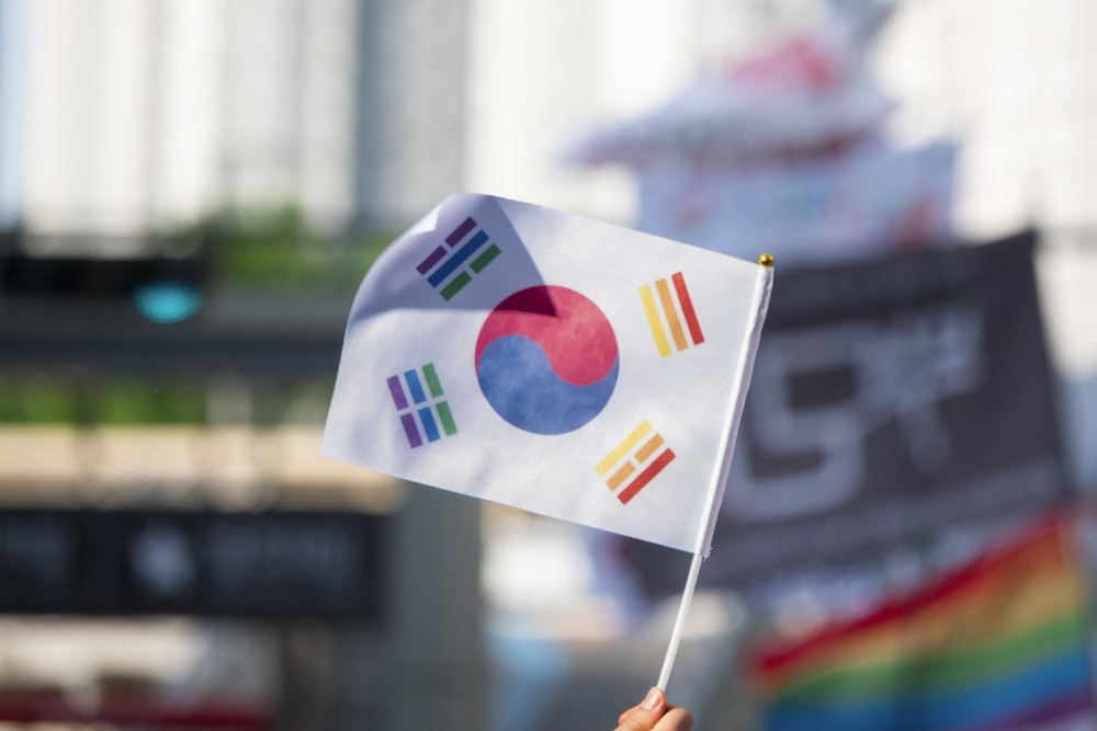 a person holding a flag in front of a building