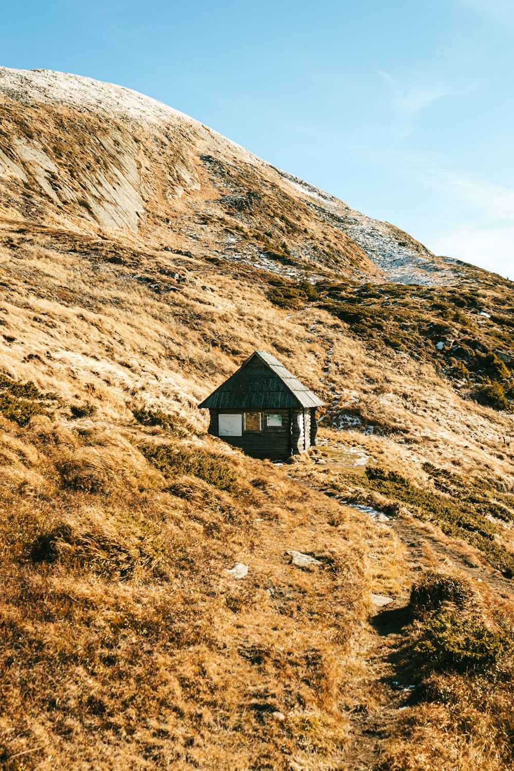 a small hut sitting on the side of a hill