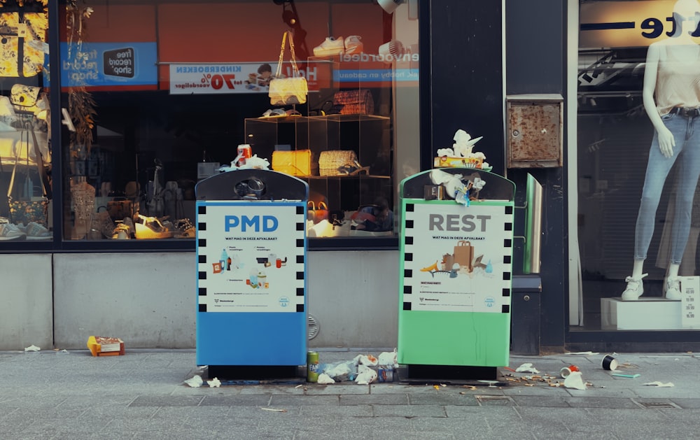 a couple of trash cans sitting on the side of a road