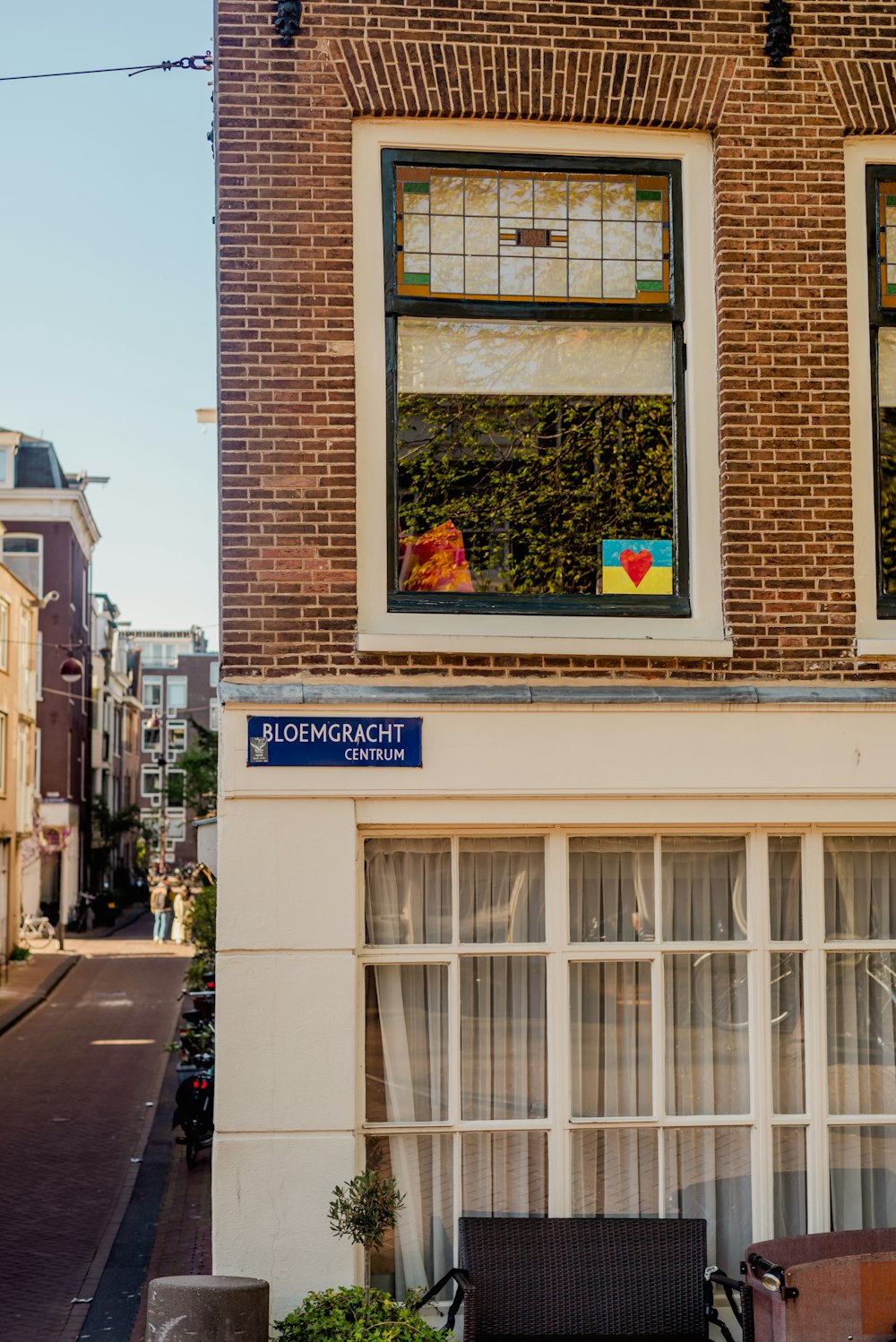 a brick building with two windows and a bench in front of it