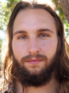 A close-up portrait of an indigenous elder surrounded by natural forest background