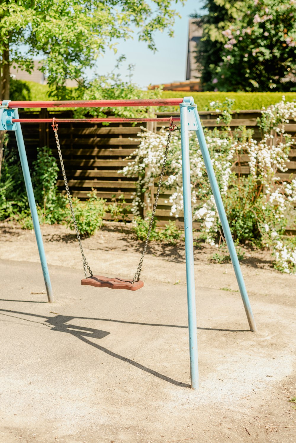 a swing set in a park with trees in the background