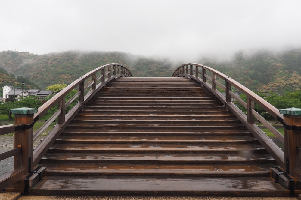 un pont en bois avec des balustrades menant au sommet de celui-ci