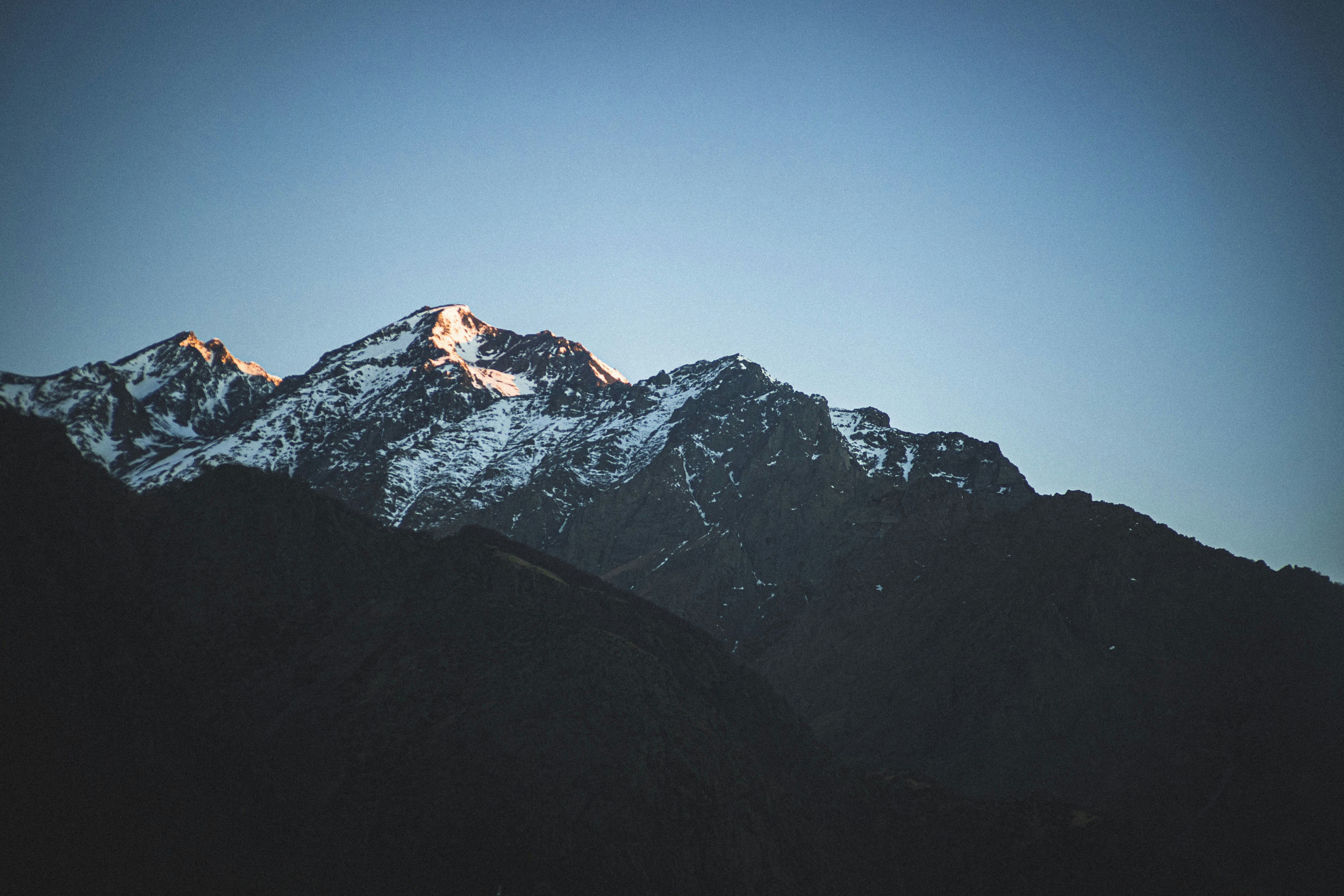 Una montagna innevata con un cielo blu sullo sfondo