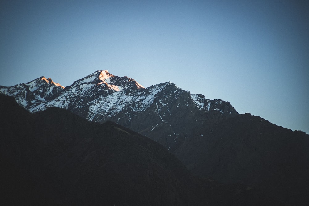 a snow covered mountain with a blue sky in the background