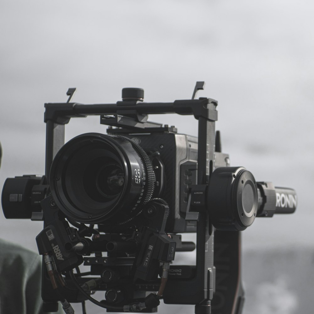 a camera attached to a tripod with a man in the background