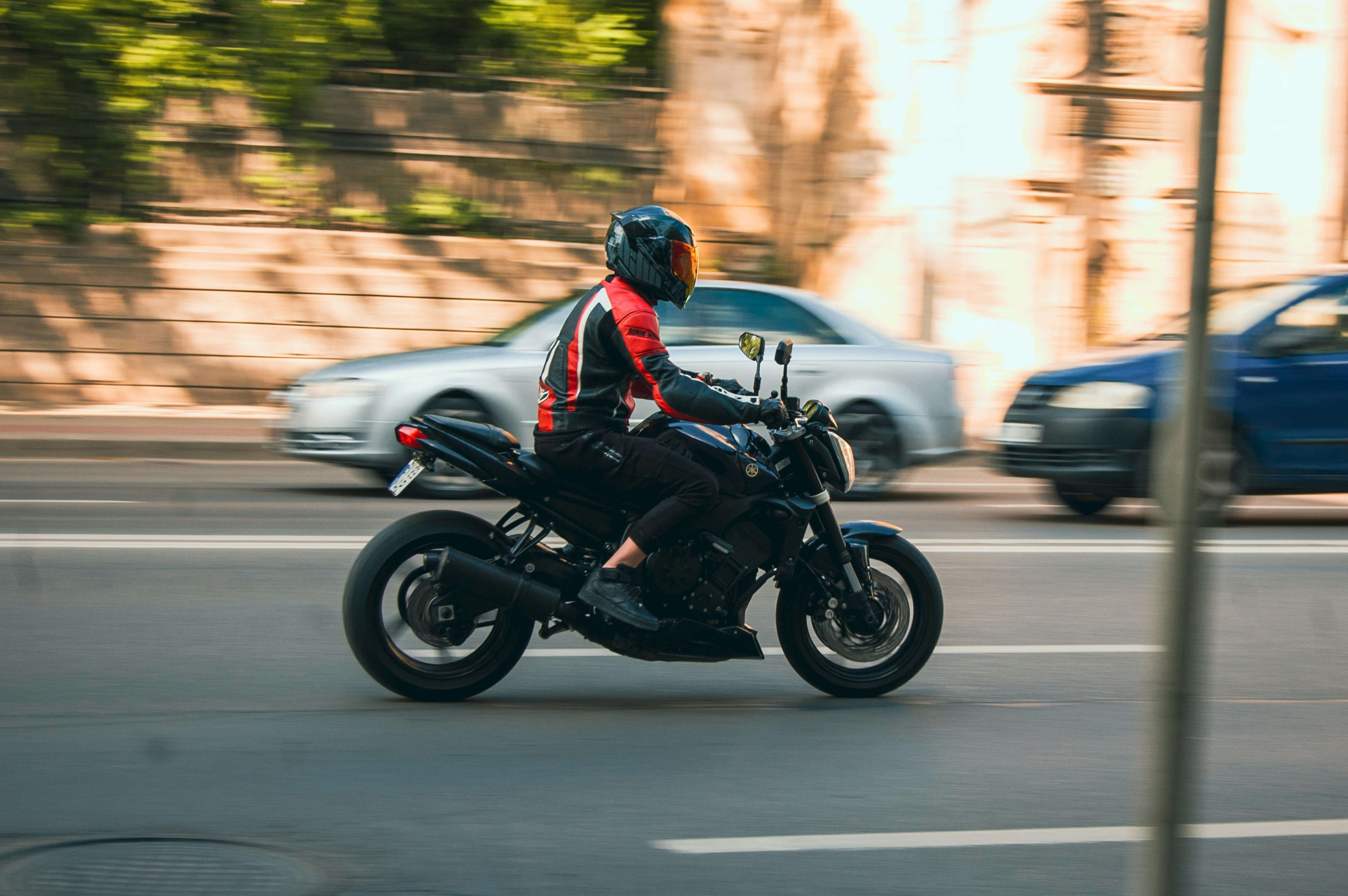 a man riding on the back of a motorcycle down a street