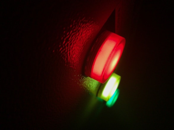 a close up of a red and green light representing alarm conditions