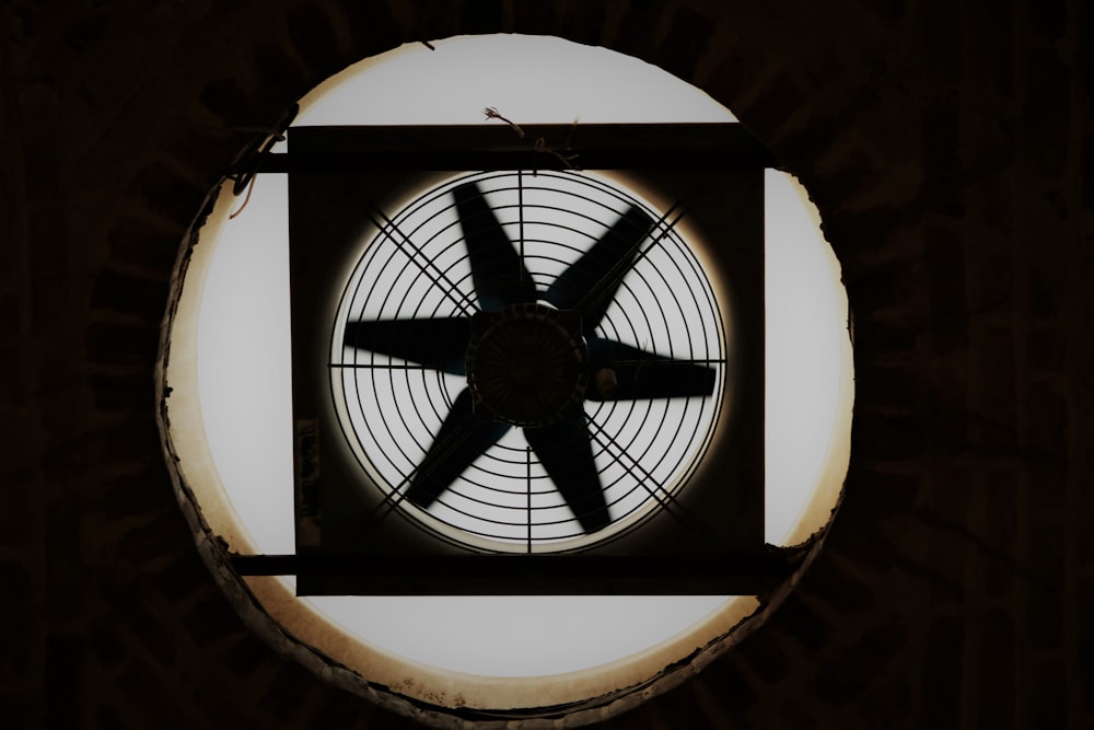 a round window with a fan in the middle of it