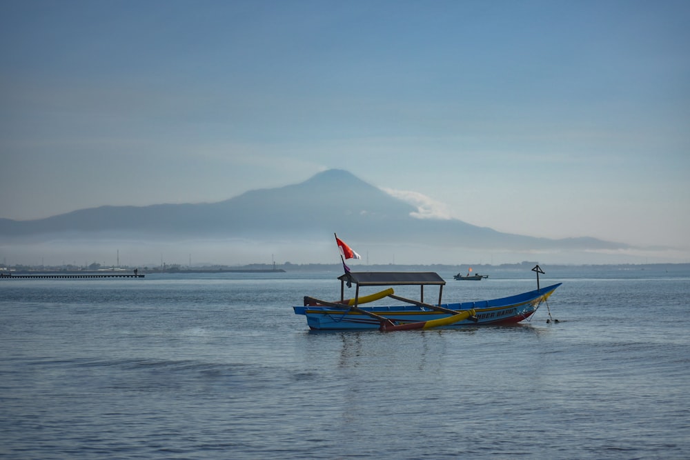 a blue boat floating on top of a large body of water