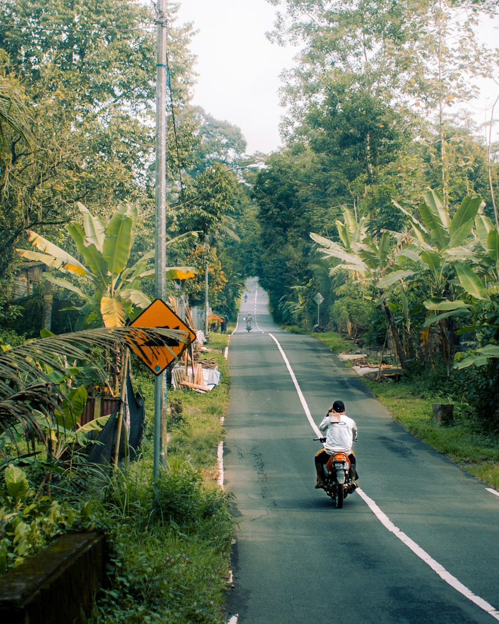 a man riding a motorcycle down a street