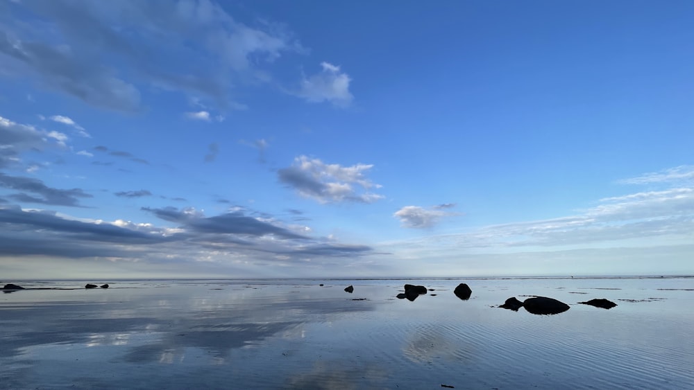 a body of water surrounded by rocks under a cloudy sky