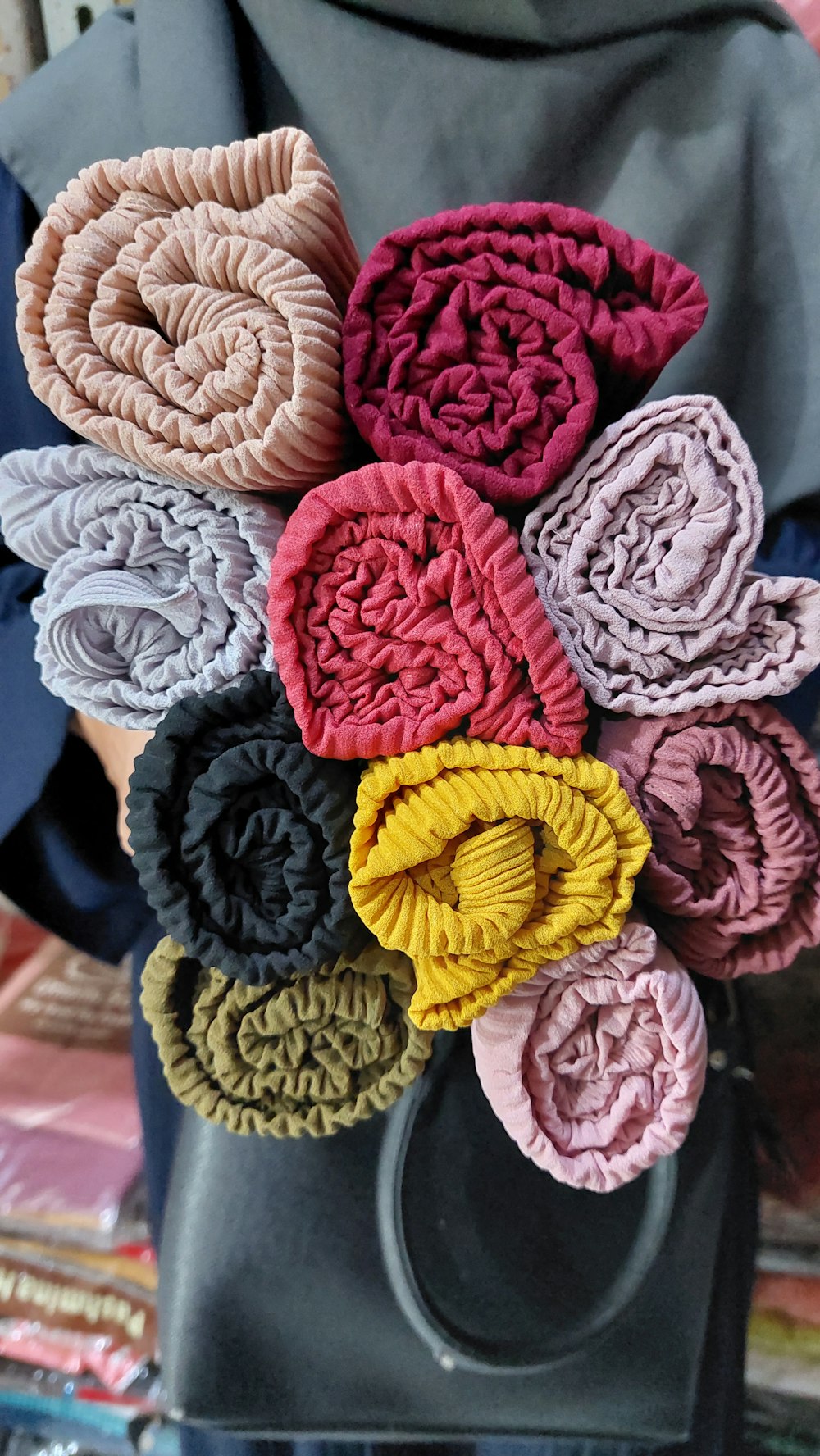 a person holding a bunch of cloth flowers