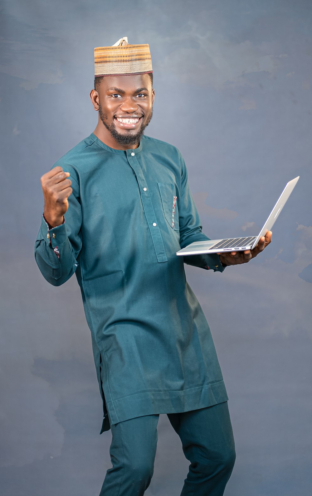 a man in a green outfit holding a laptop