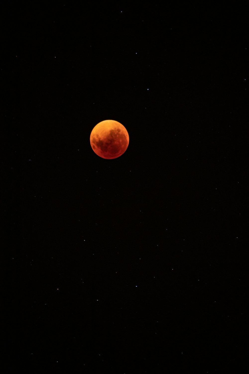 a red moon is seen in the night sky